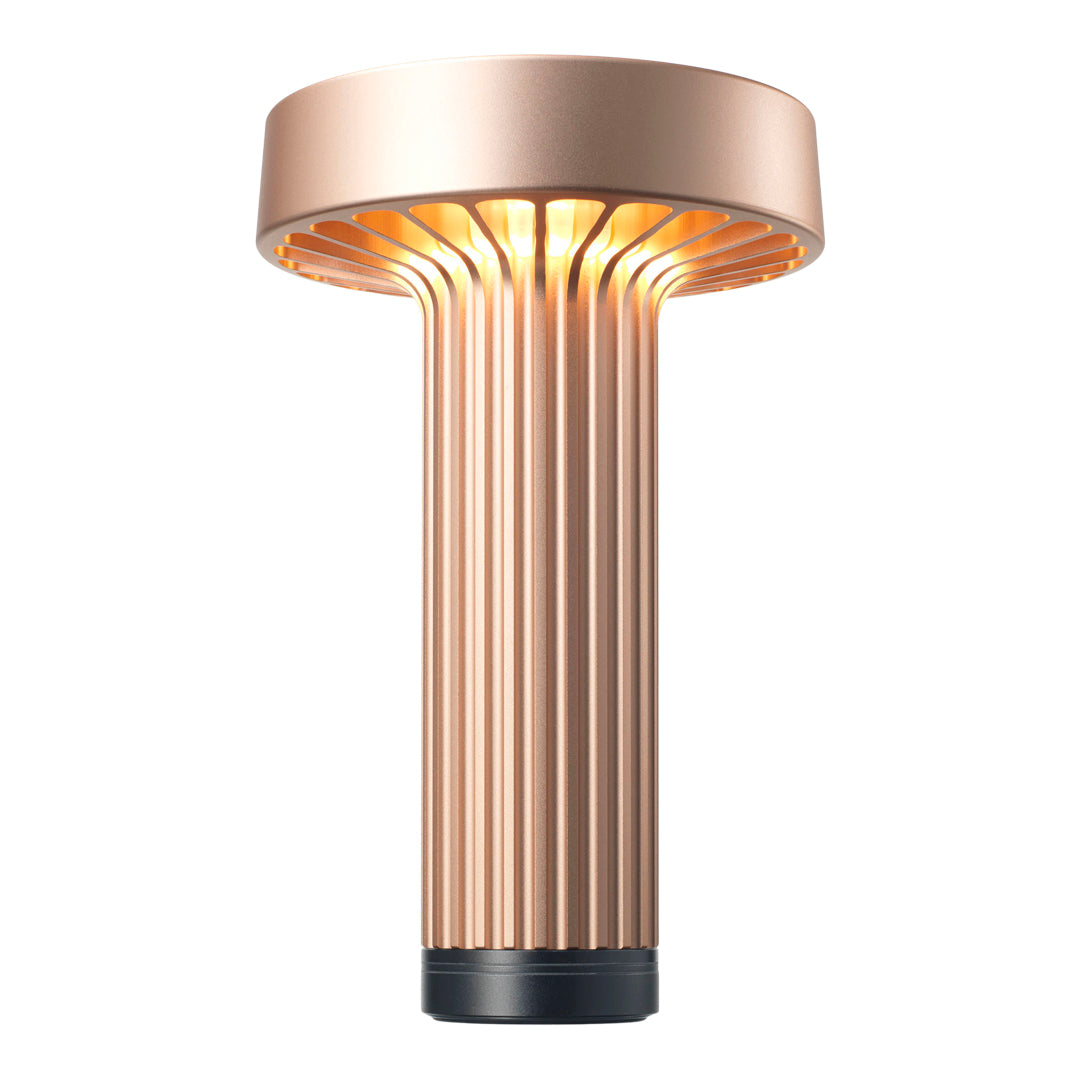 Rose gold lamp with vertical ribbed design and warm glowing light, adding a modern touch to any space.