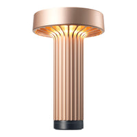 Rose gold lamp with vertical ribbed design and warm glowing light, adding a modern touch to any space.