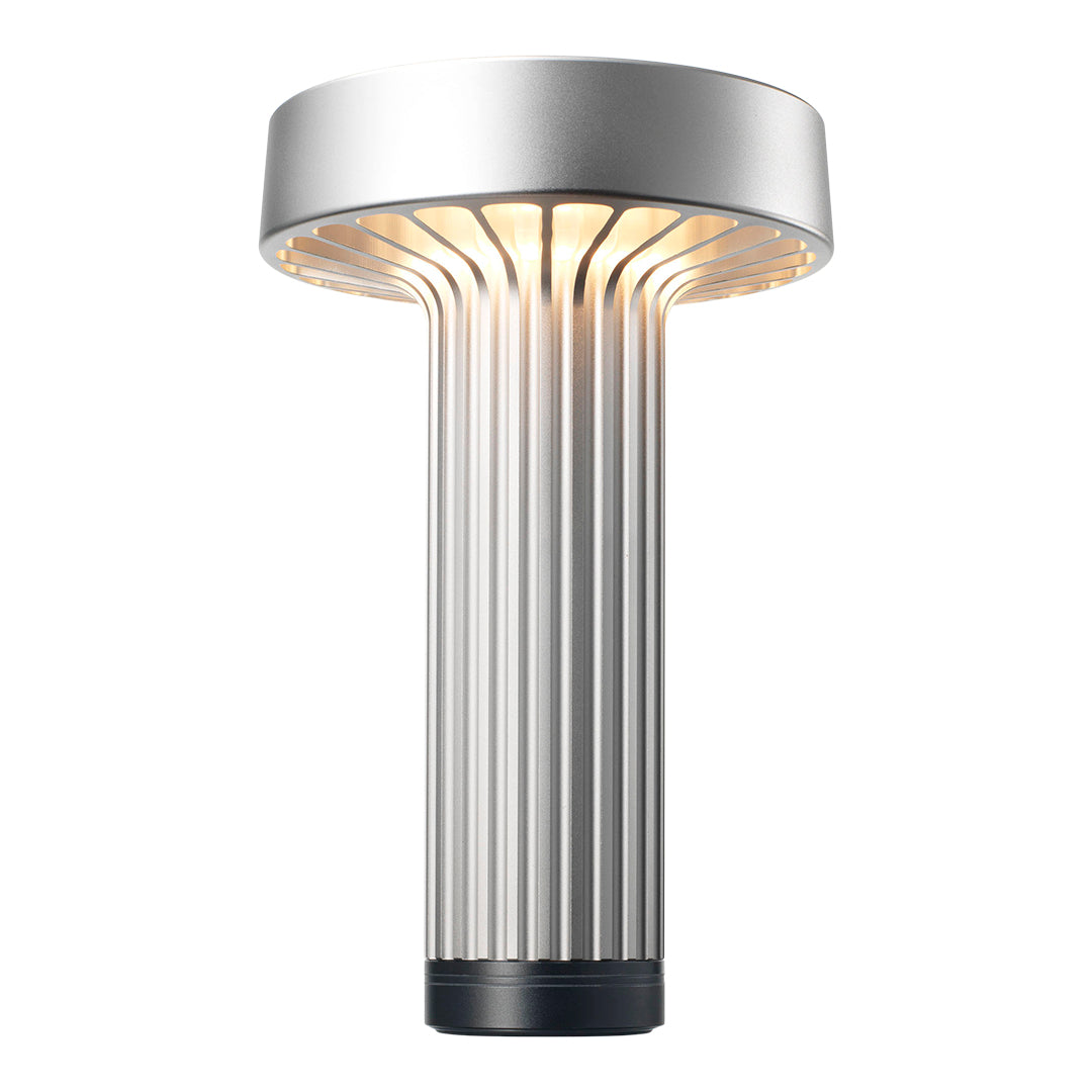 Sleek silver lamp with ribbed texture and warm glow, perfect for modern decor.