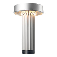 Sleek silver lamp with ribbed texture and warm glow, perfect for modern decor.