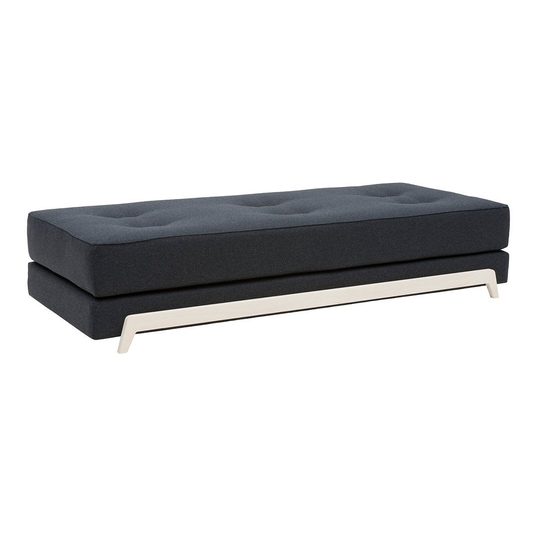 Black tufted sofa upholstered in a sleek fabric, featuring a modern silver base and minimalist design.