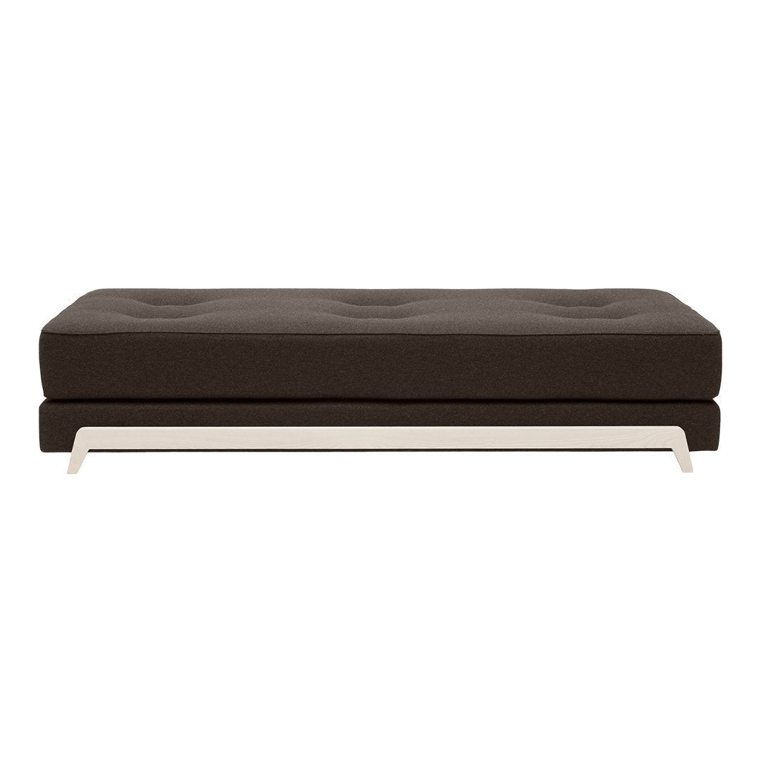 Brown upholstered sofa with tufted design and sleek white metal base, ideal for modern interiors.