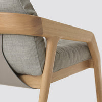 Light grey fabric with subtle texture and natural wood armrests create a modern, minimalist design.