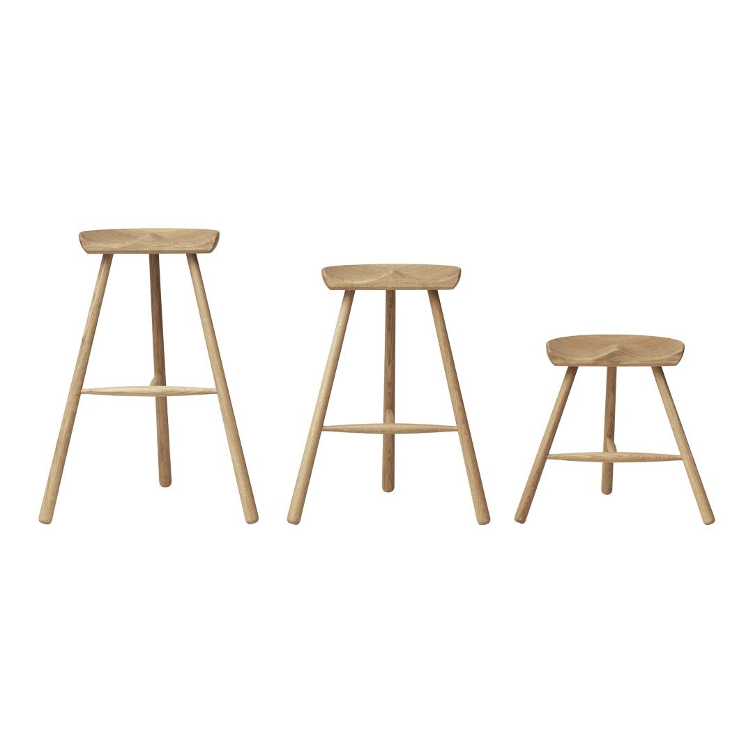 Set of three natural wood stools with a smooth finish and minimalist design, featuring light beige tones.