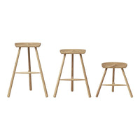 Set of three natural wood stools with a smooth finish and minimalist design, featuring light beige tones.