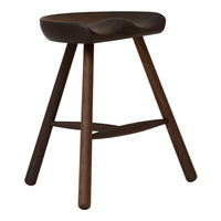 "Dark brown wooden stool with a smooth curved seat and tapered legs, showcasing a minimalist design and natural finish."