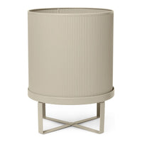 Beige ribbed planter on a cross-legged metal stand, textured design adds modern elegance to any space.