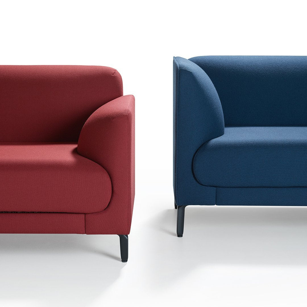 Two modern sofas in rich red and deep blue upholstery, showcasing sleek lines and minimalist design.
