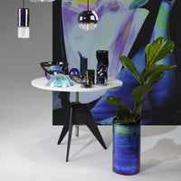 "Glossy iridescent decor in blue and purple hues, featuring geometric patterns against a modern tabletop and backdrop."