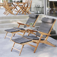 "Gray cushioned reclining chairs with wooden frames, set against a neutral outdoor backdrop."
