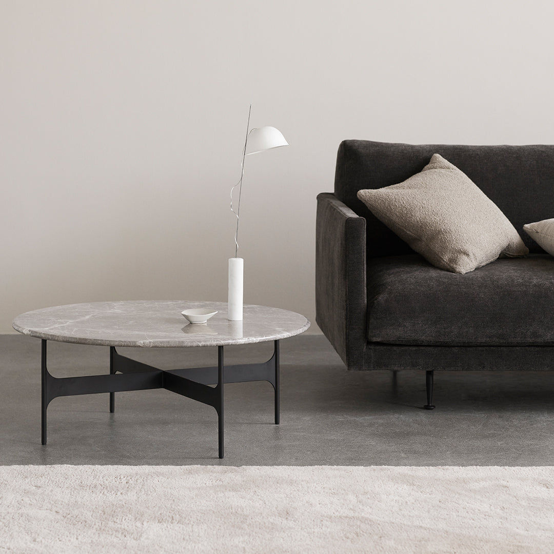 Stylish gray marble coffee table with sleek black legs, paired with a modern dark sofa and neutral accents.