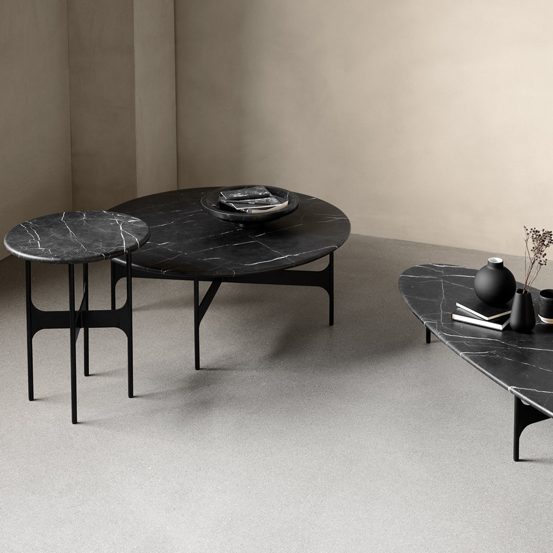 Black marble coffee tables with white veining, featured in a minimalist setting. Elegant and modern design.