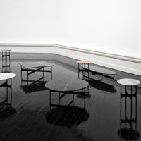 Assorted coffee tables featuring black, white, and gray marble tops with sleek black metal bases, modern geometric designs.