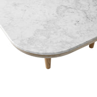 Close-up of a white marble tabletop with subtle gray veining and natural wooden legs. Elegant and modern design.