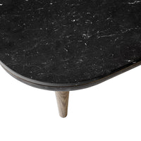 Black marble tabletop with white veining and a smooth edge, paired with a light wooden leg.