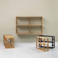 "Natural wood grain shelves in light brown and black, featuring geometric designs against a soft beige wall."