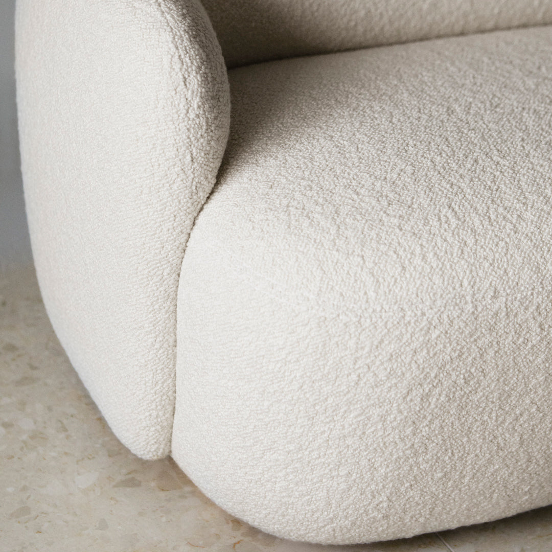 Creamy textured upholstery on a modern sofa with rounded edges and a soft, inviting appearance.