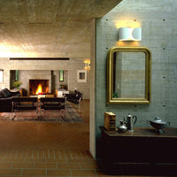 Modern living room featuring earthy tones, textured gray walls, warm wood accents, and a patterned rug.