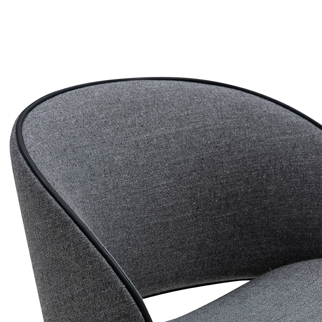 Gray upholstered chair detail with smooth texture and black piping accent.