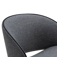 Gray upholstered chair detail with smooth texture and black piping accent.