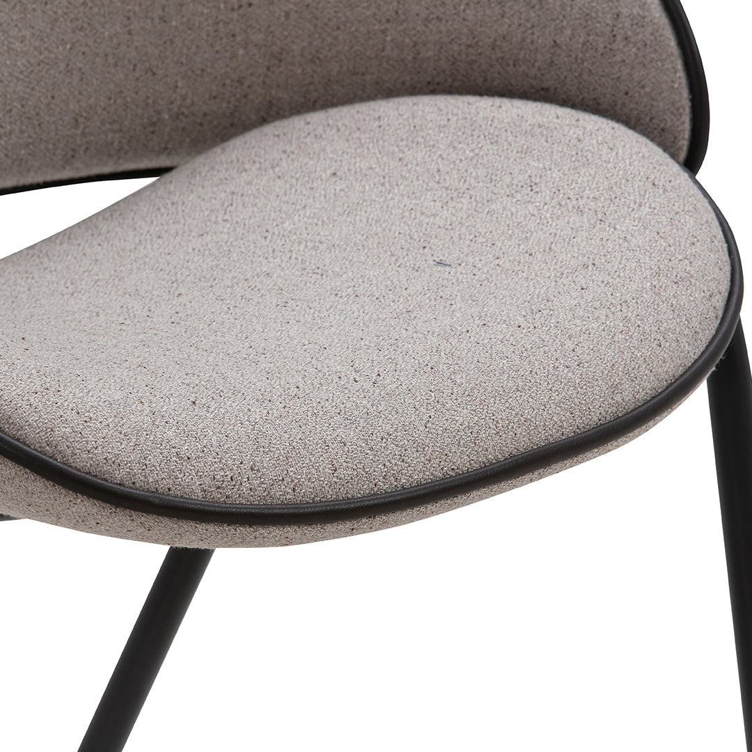 Light gray textured fabric chair cushion with a sleek black trim, showcasing modern design and minimalistic aesthetics.