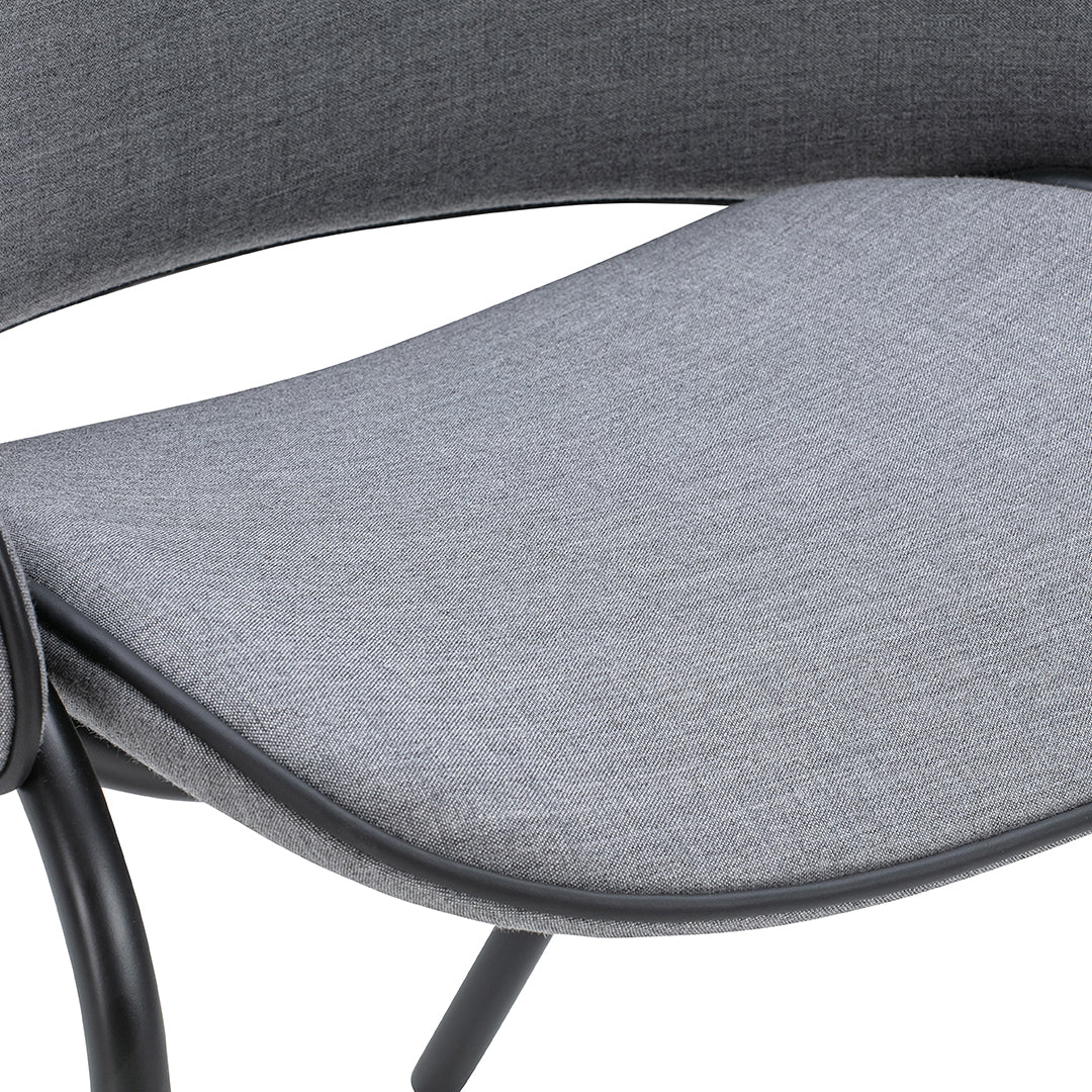 Gray textured fabric seat with smooth curves and black metal frame, perfect for modern decor.