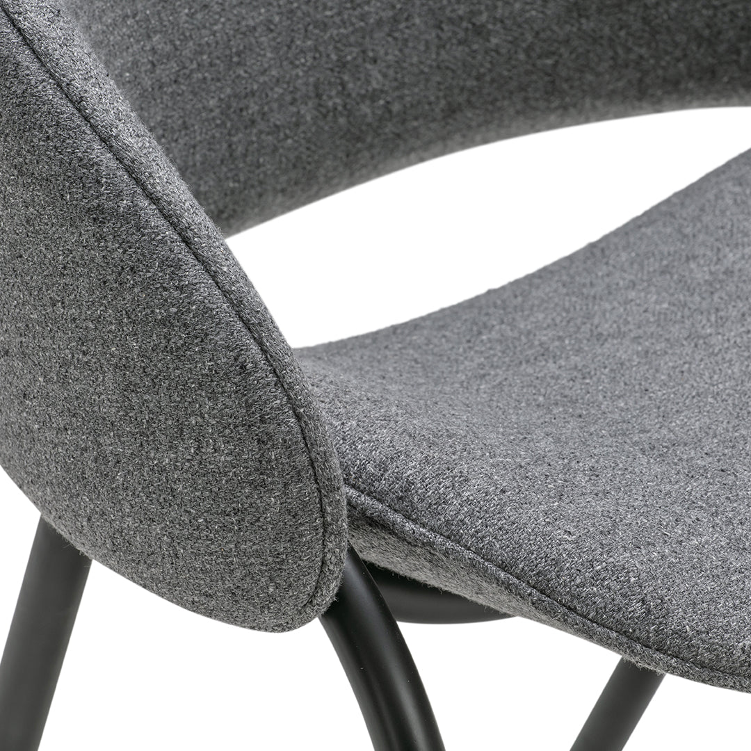 Gray upholstered chair with a sleek, curved design and black metal legs. Textured fabric adds modern elegance.
