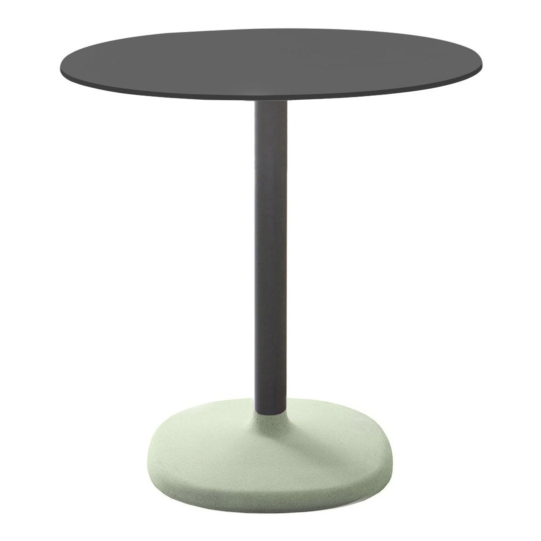 Round table featuring a matte black top and a soft green base, perfect for minimalist decor.