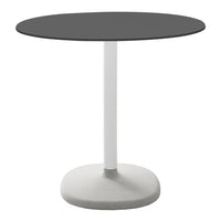 Round black tabletop with a white base, featuring a sleek, modern design ideal for minimalist decor.