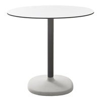 Round white tabletop with a sleek black edge on a gray base, featuring a minimalist design and modern aesthetic.