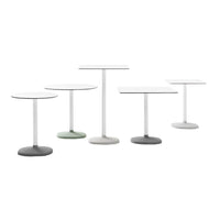Set of modern tables in white, green, and gray, featuring smooth round tops and sturdy bases.