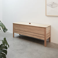 "Natural wood storage bench with light oak finish and sleek, minimalistic design, featuring smooth lines."