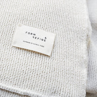 Textured cream fabric with a subtle knit pattern and a white label featuring “FORM & REFINE.”