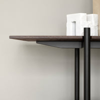 Dark wood tabletop with a sleek black metal base, featuring minimalist design and smooth lines against a neutral background.