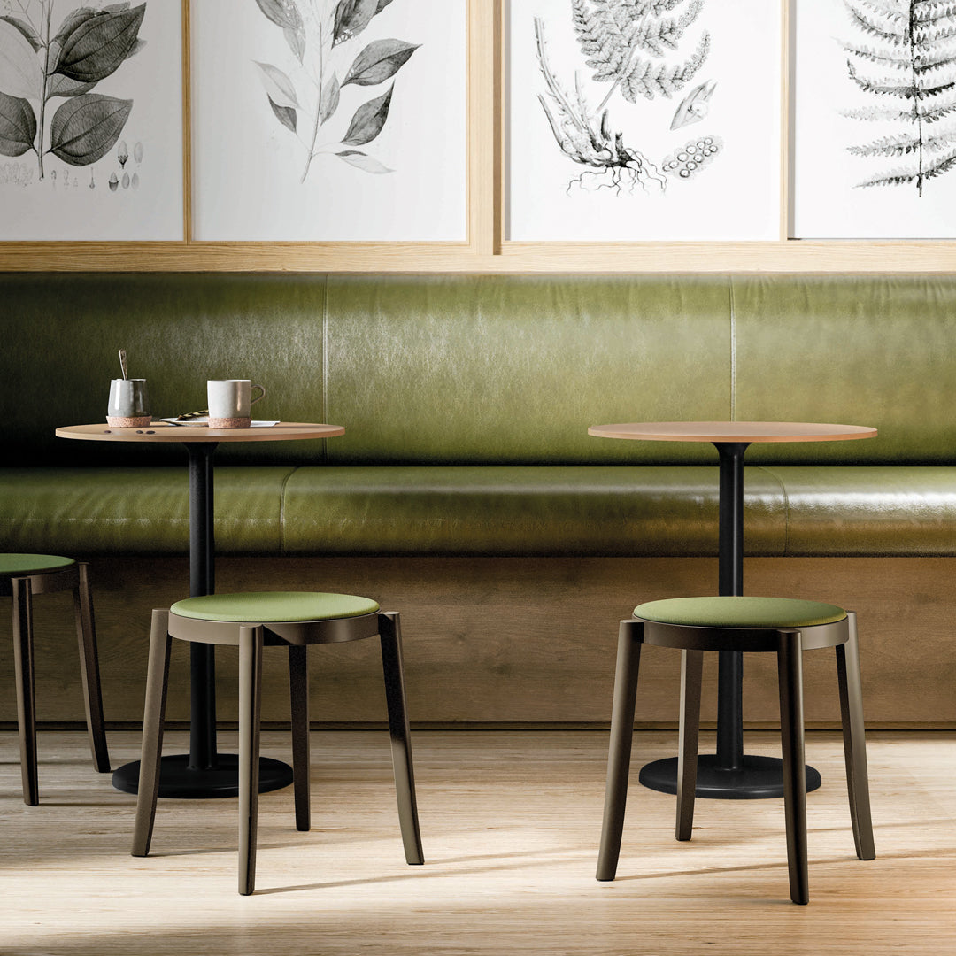"Stylish green seating and tabletops paired with natural wood patterns in a modern café setting."