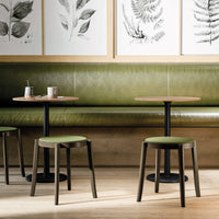 "Stylish green seating and tabletops paired with natural wood patterns in a modern café setting."