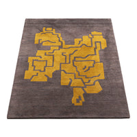 Abstract gray rug featuring a bold yellow geometric pattern. Perfect for modern home decor.