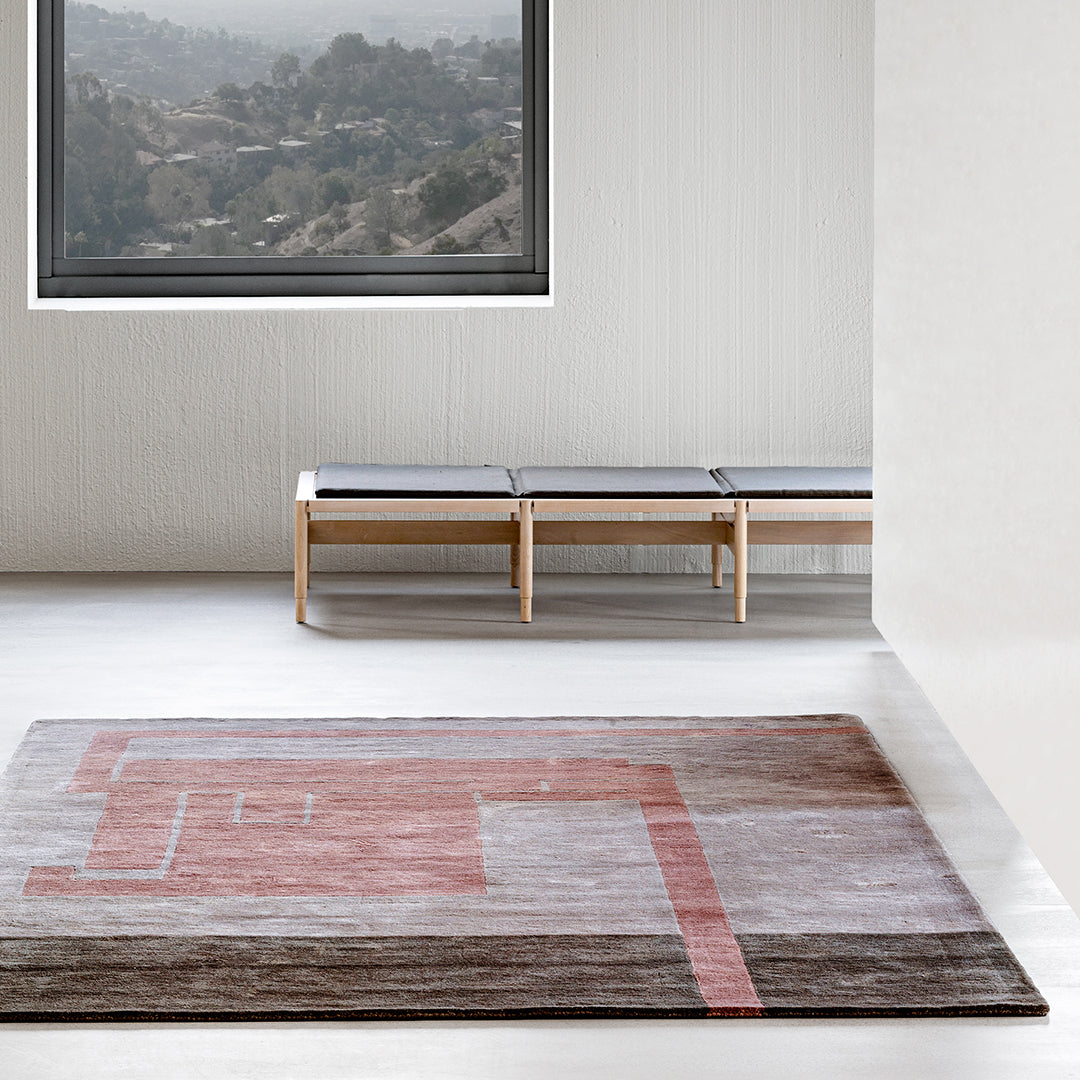 Multicolored area rug featuring geometric patterns in soft pink, gray, and beige tones, ideal for modern decor.