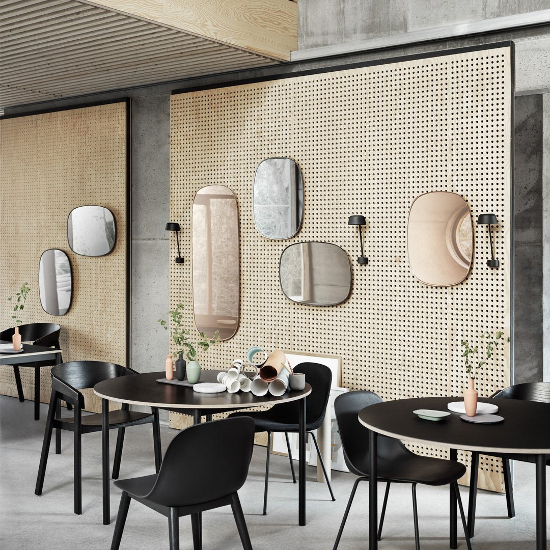 Modern decor featuring earthy tones, minimalist mirrors, and textured beige wall patterns in a stylish dining space.