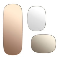 Set of three decorative mirrors: rose gold, clear, and soft beige frames with sleek, modern shapes.