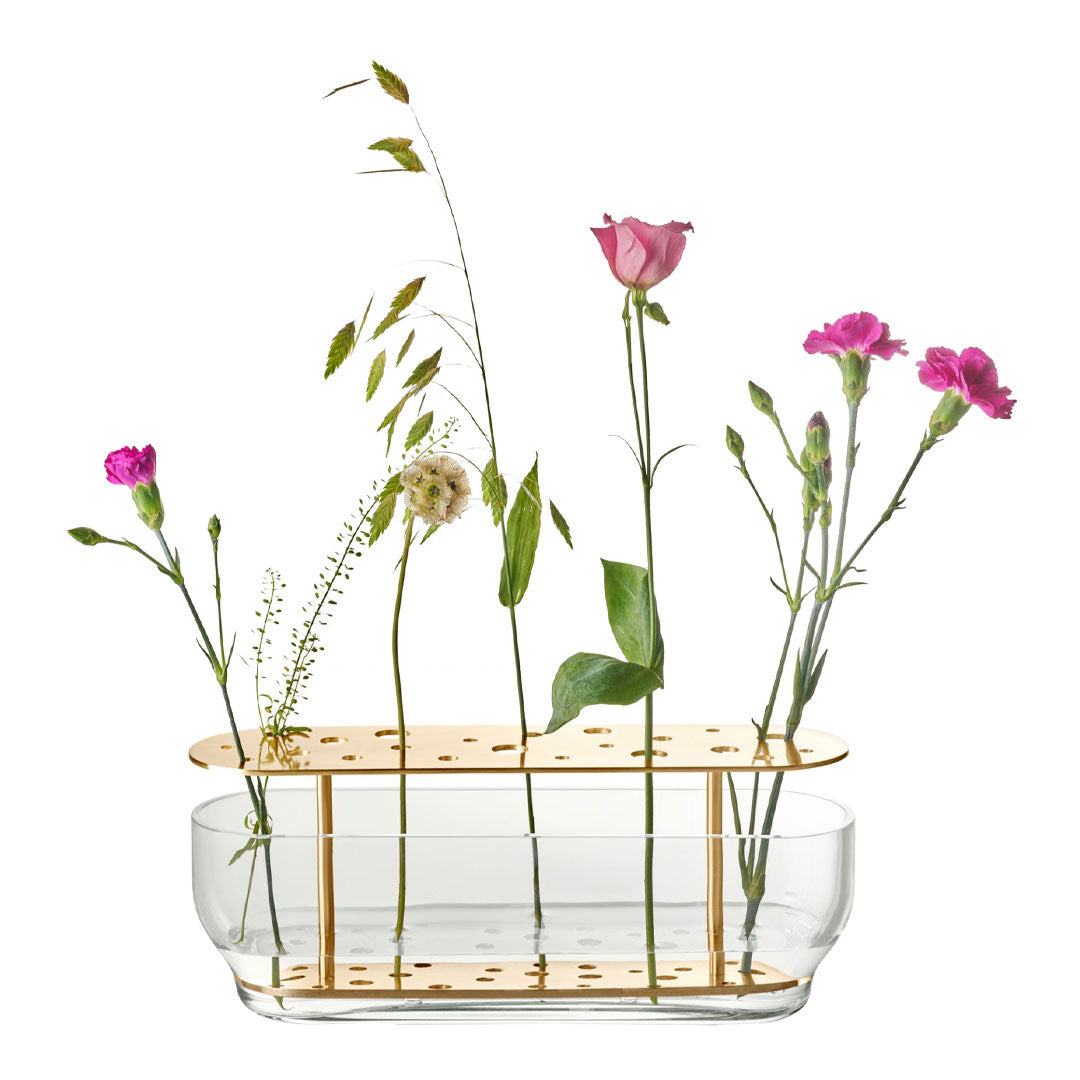 Clear glass vase with gold polka dot pattern, featuring pink and green floral arrangements.