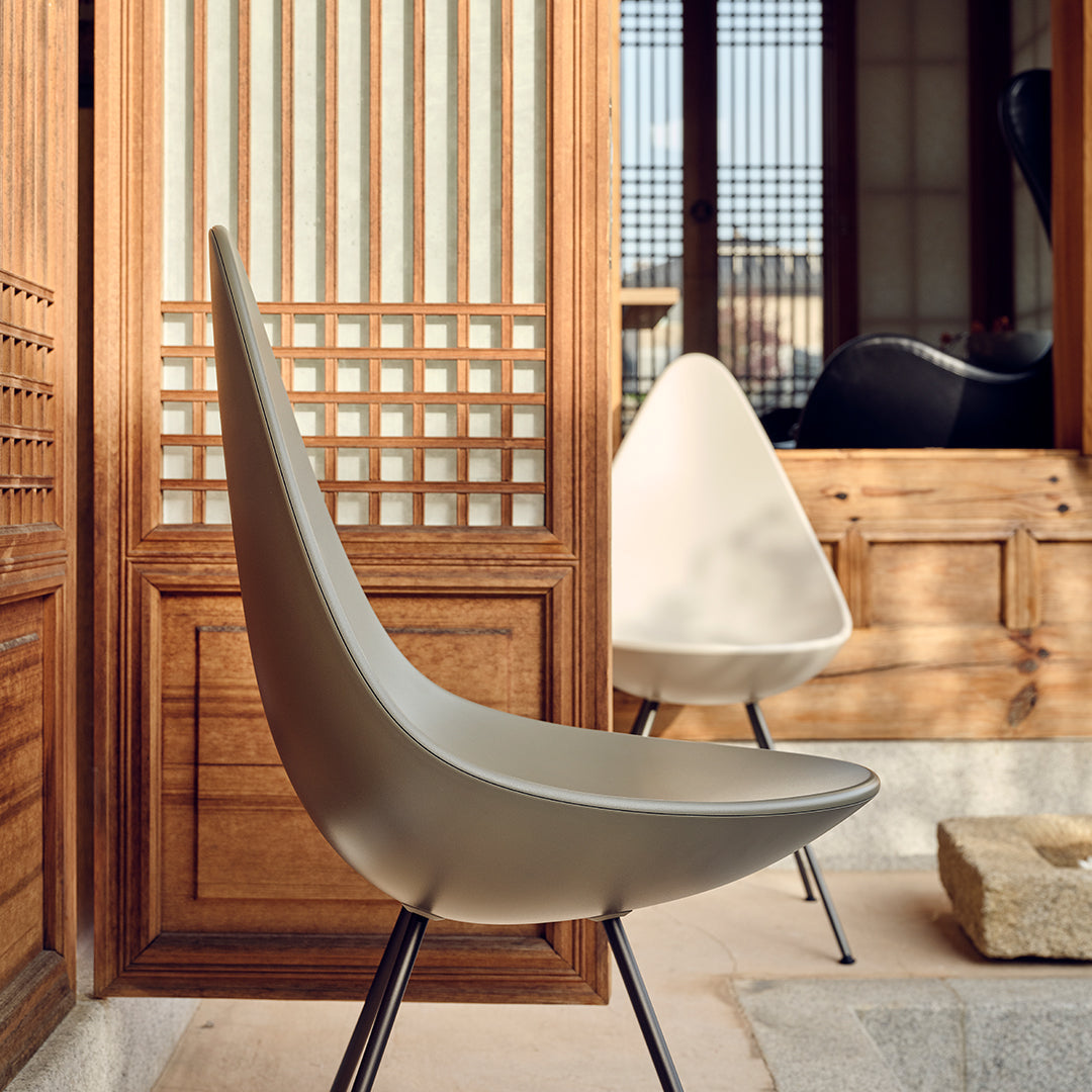 Modern cream chairs with sleek curves, contrasting against natural wood and traditional lattice patterns.