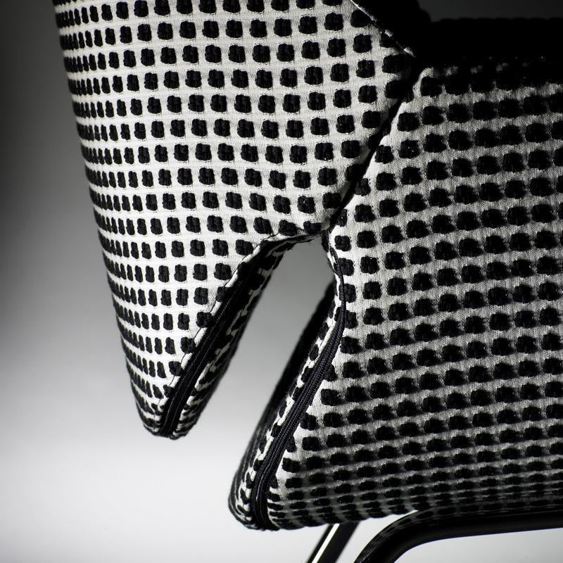 Black and white checkered pattern fabric on contemporary chair, highlighting bold geometric design.