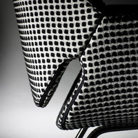 Black and white checkered pattern fabric on contemporary chair, highlighting bold geometric design.