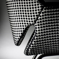 Black and white patterned chair close-up featuring a grid design and contrasting edge detailing.