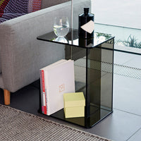 Elegant black glass side table with a minimalist design, featuring a geometric pattern and a sleek, modern finish.