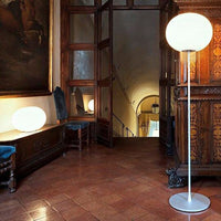 "Modern white globe floor lamp with a sleek metal base, set against warm wood tones and classic decor."
