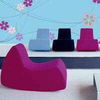 "Colorful modern seating: bold magenta, soft blue, deep navy, and vibrant pink, against a playful floral wall pattern."