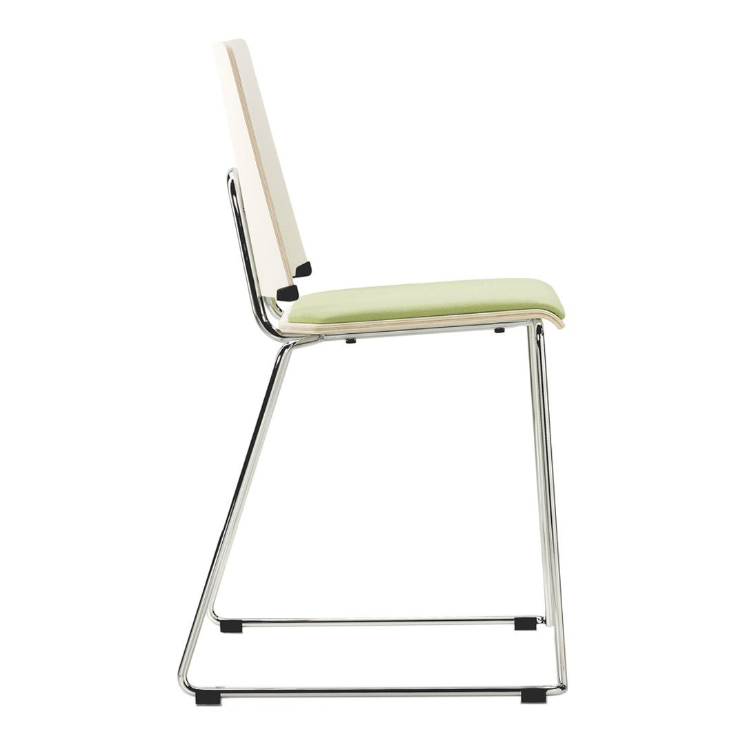 Side view of a sleek chair with a light green cushion and a clean white backrest, featuring a chrome frame.