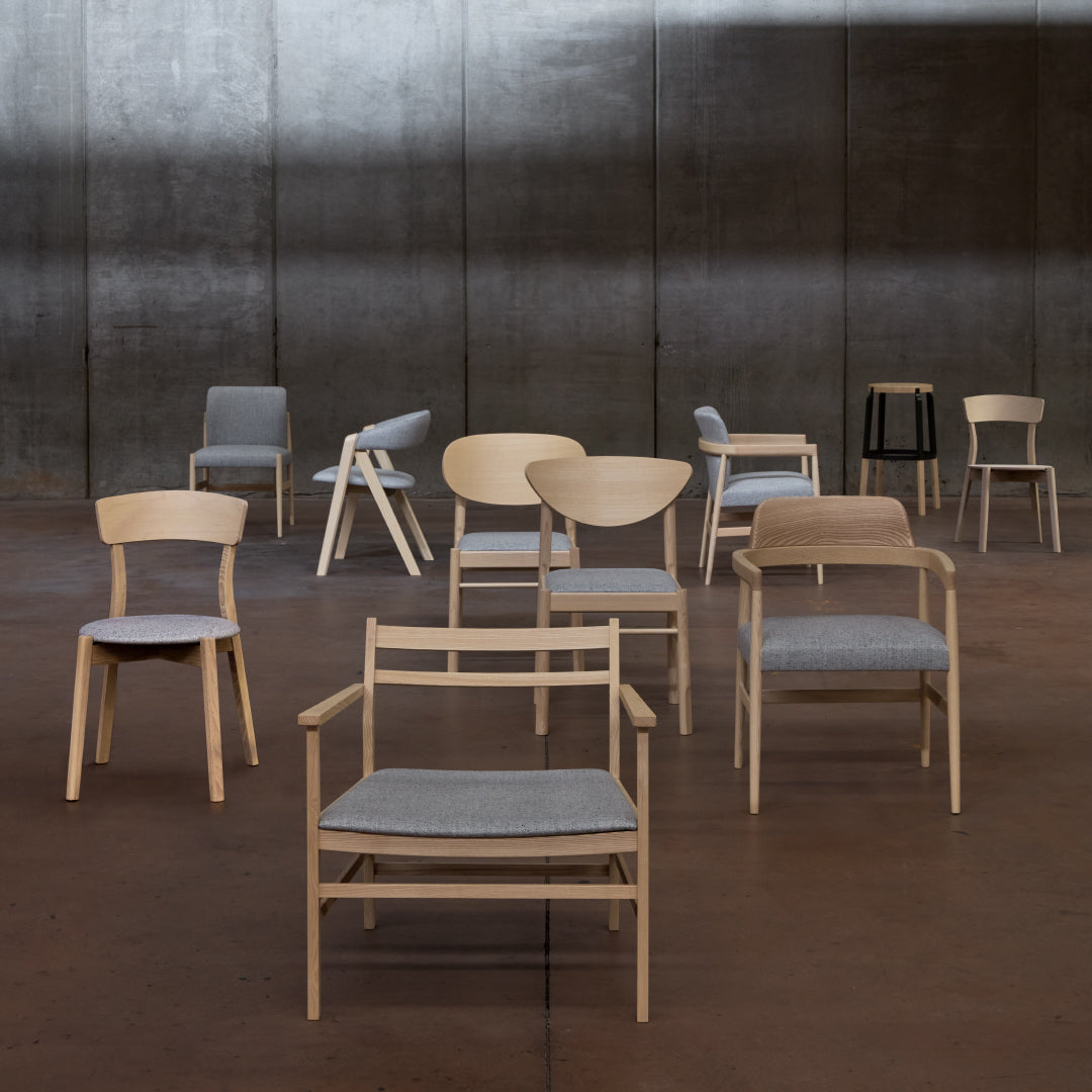 Collection of modern chairs in natural wood tones and gray upholstery, featuring various shapes and styles.